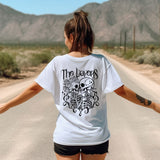 a woman walking down a road with her arms outstretched