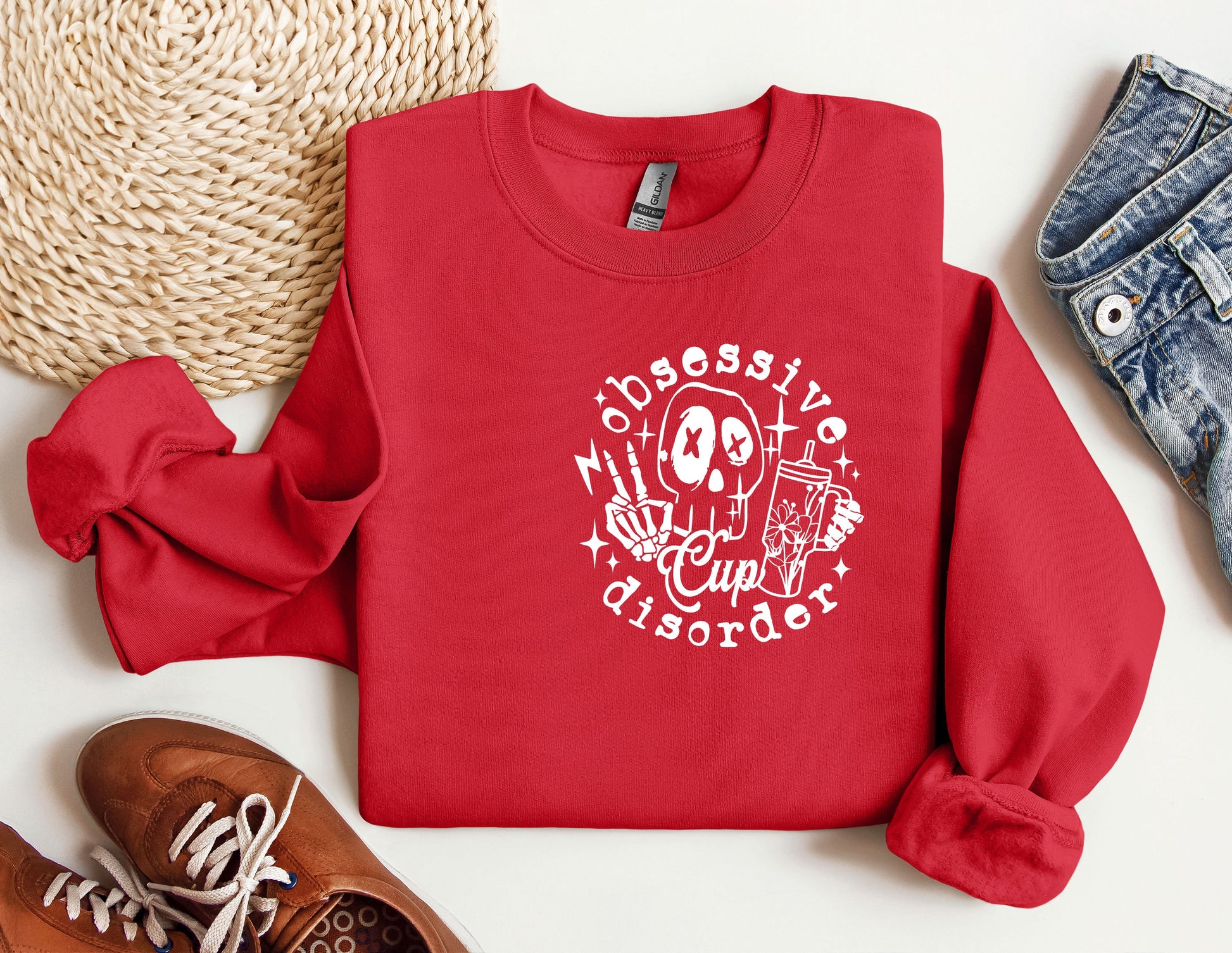 a red sweatshirt with a skull on it next to a pair of shoes