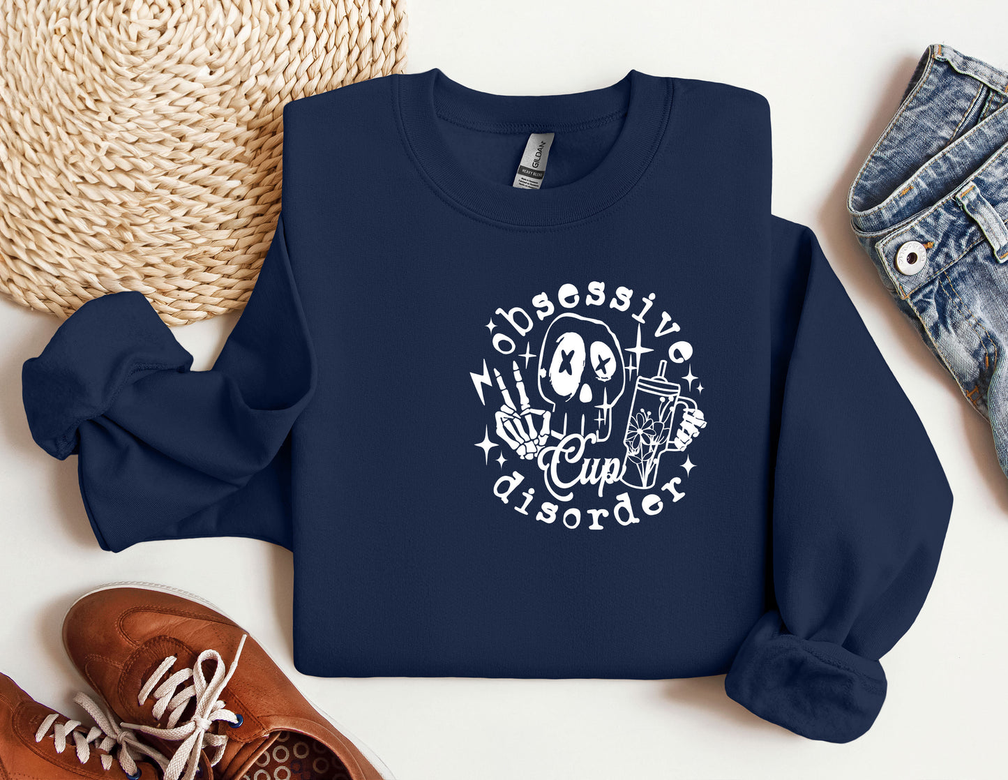 a blue sweatshirt with a skull on it next to a pair of shoes