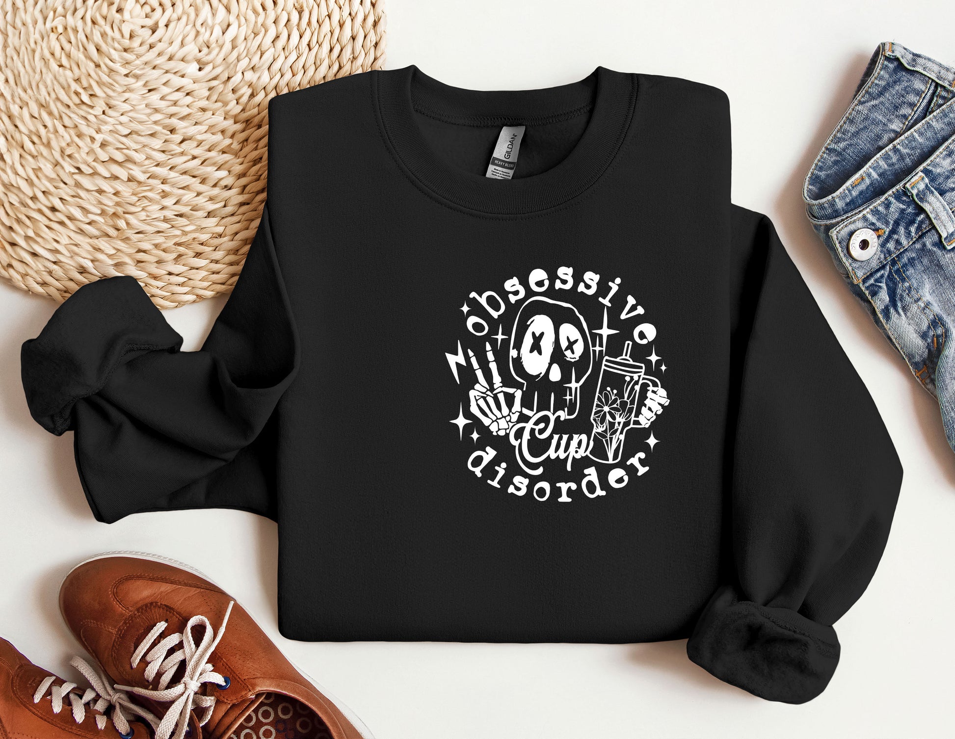 a black sweatshirt with a skeleton on it next to a pair of shoes