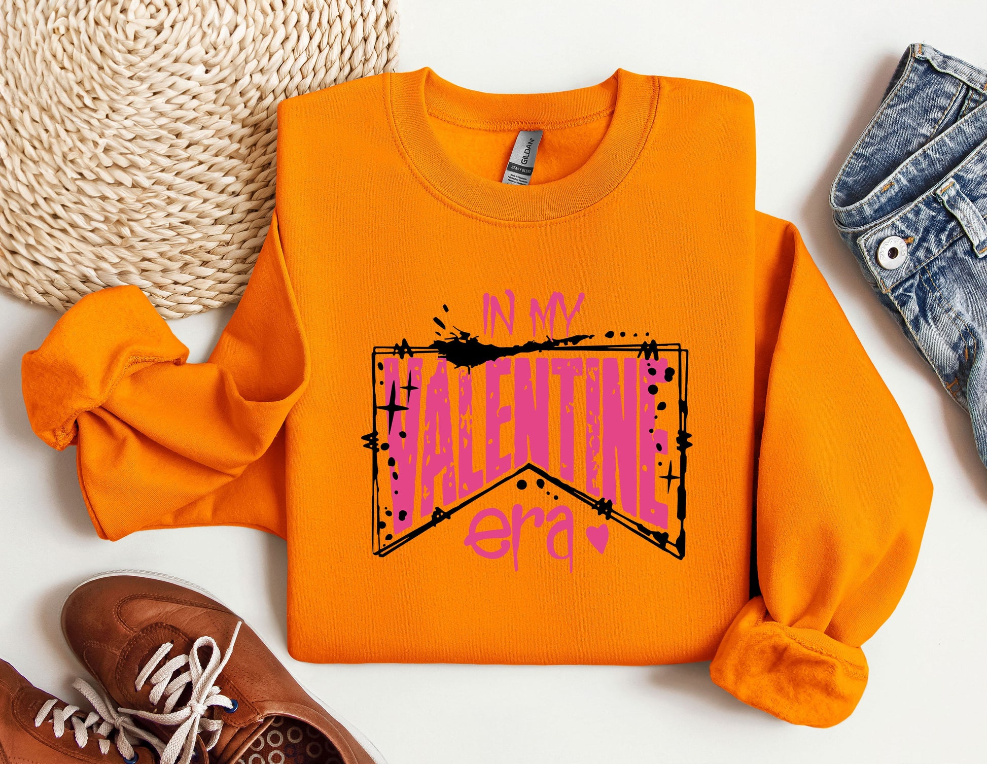 a pair of shoes and an orange sweatshirt on a white surface