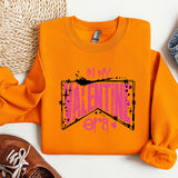 a pair of shoes and an orange sweatshirt on a white surface