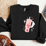 a black sweatshirt with a pink drink on it