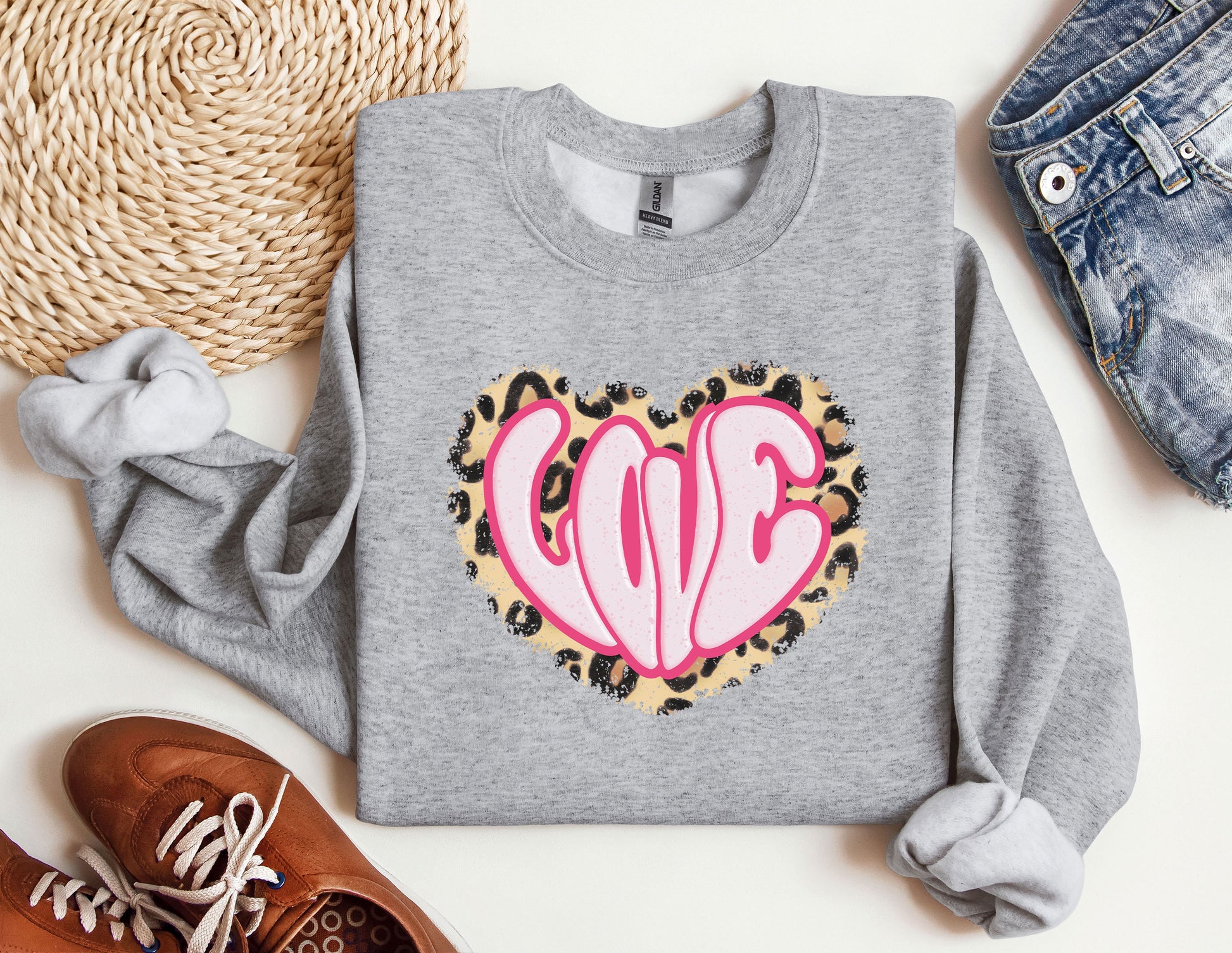 a gray sweatshirt with a pink heart on it