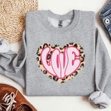 a gray sweatshirt with a pink heart on it