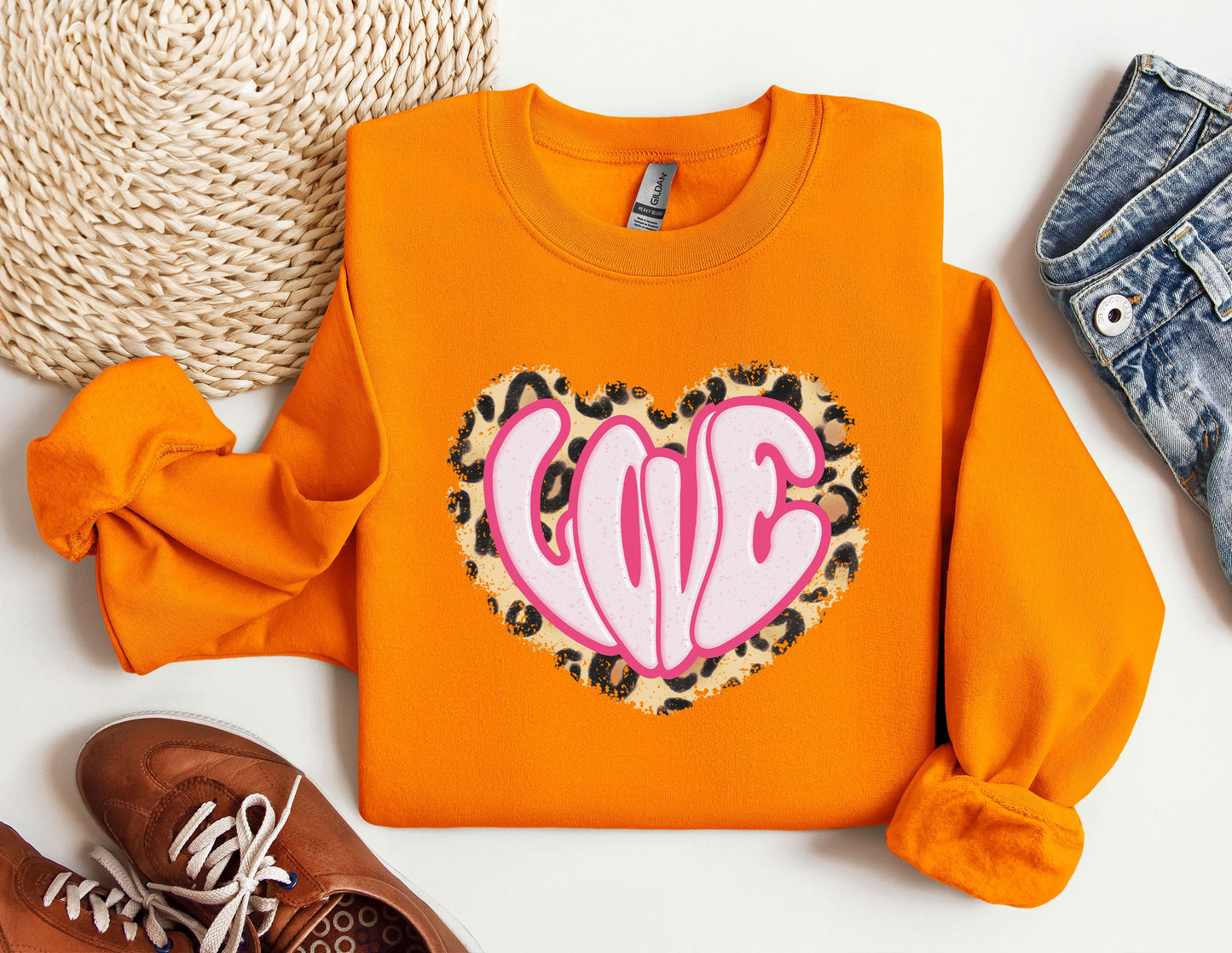 a pair of shoes and an orange sweatshirt with a heart on it