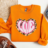a pair of shoes and an orange sweatshirt with a heart on it