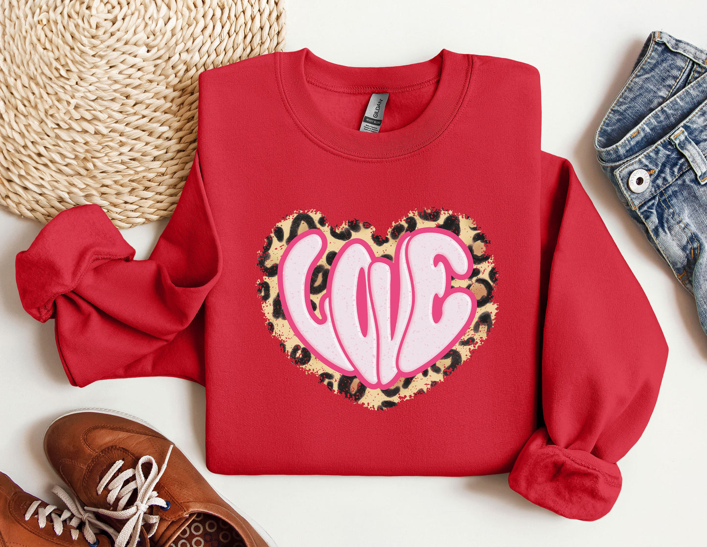 a red sweater with a leopard print heart on it