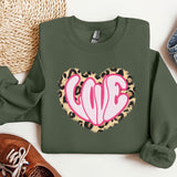 a green sweatshirt with a pink heart on it