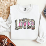 a white sweatshirt with the word loved printed on it