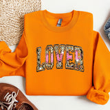 a pair of shoes and an orange sweatshirt with the word love on it