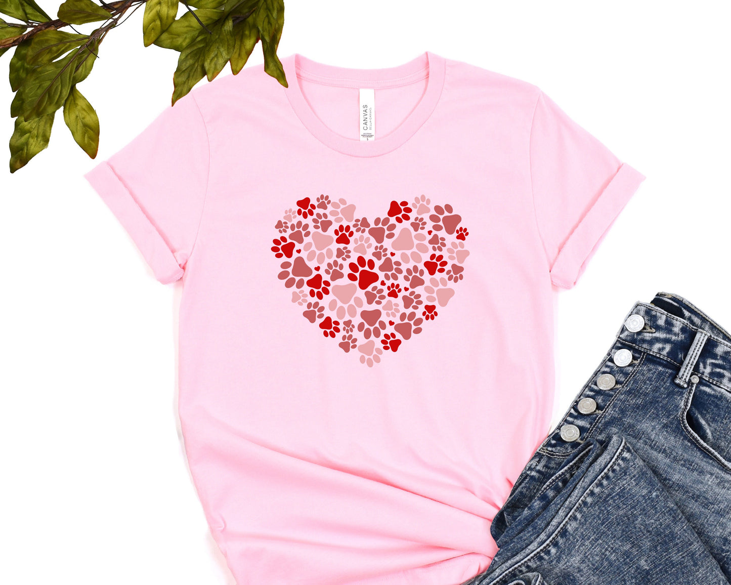 a pink t - shirt with a heart made out of paw prints