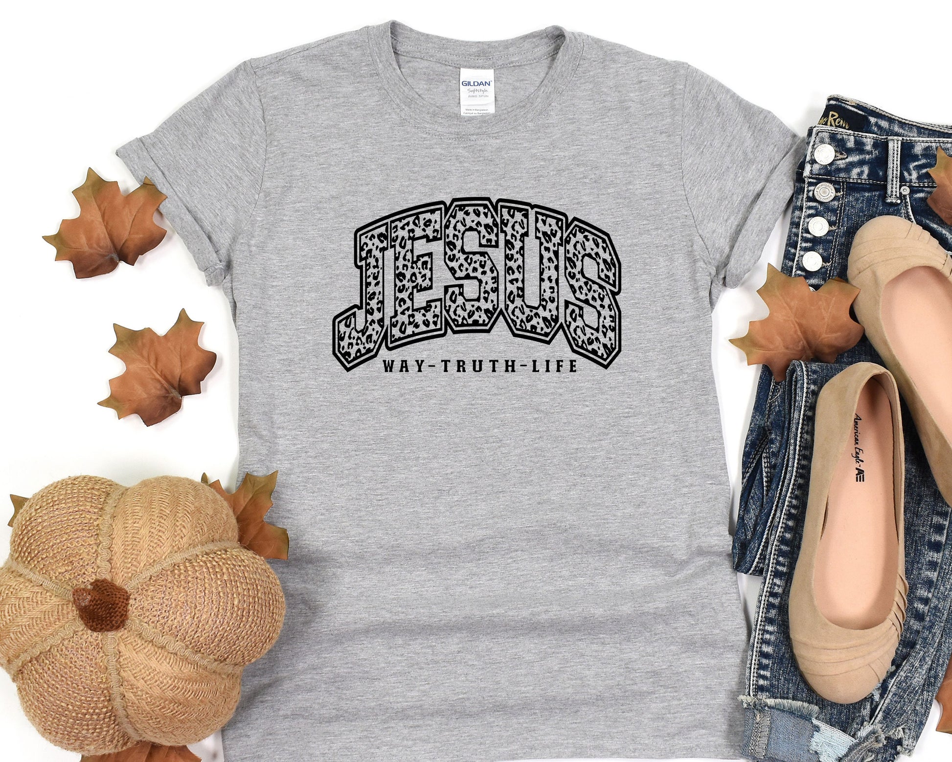 a t - shirt with the words texas on it next to a pair of jeans