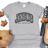 a t - shirt with the words texas on it next to a pair of jeans