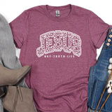 a t - shirt with the word jesu on it next to a pair of