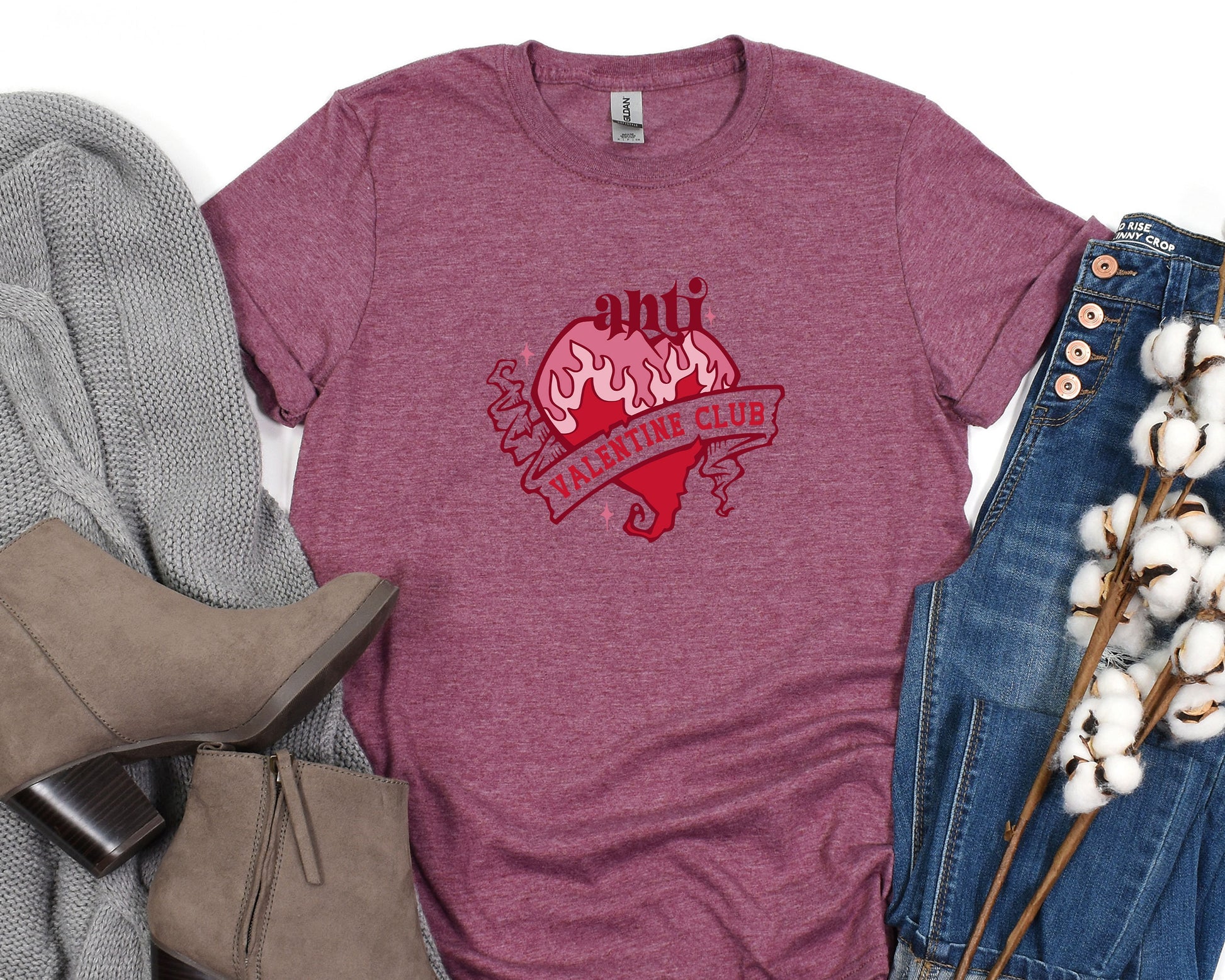 a t - shirt with a heart on it next to a pair of jeans