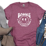 a t - shirt with a smiley face on it next to a pair of jeans