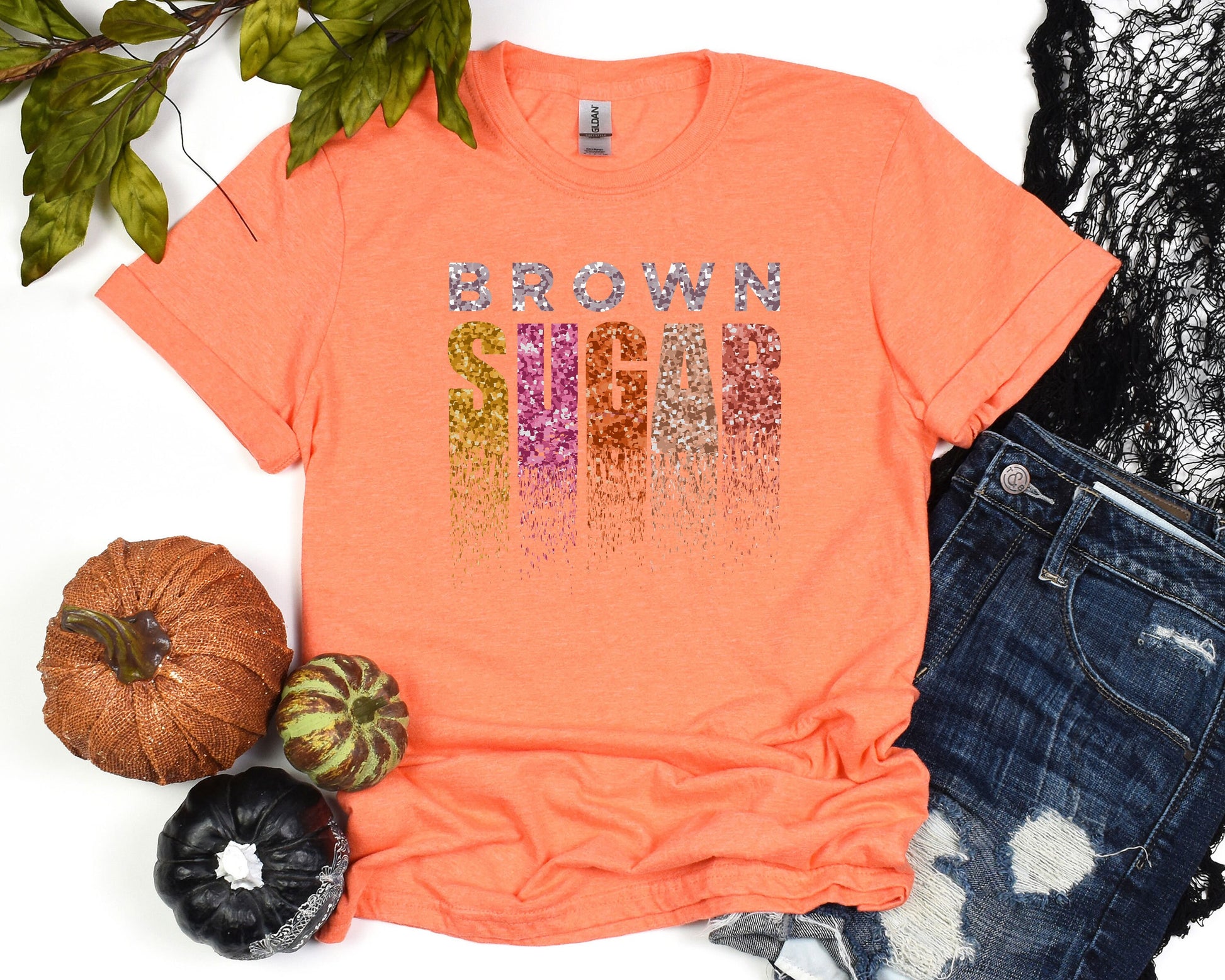 a t - shirt with the word mom on it next to some pumpkins