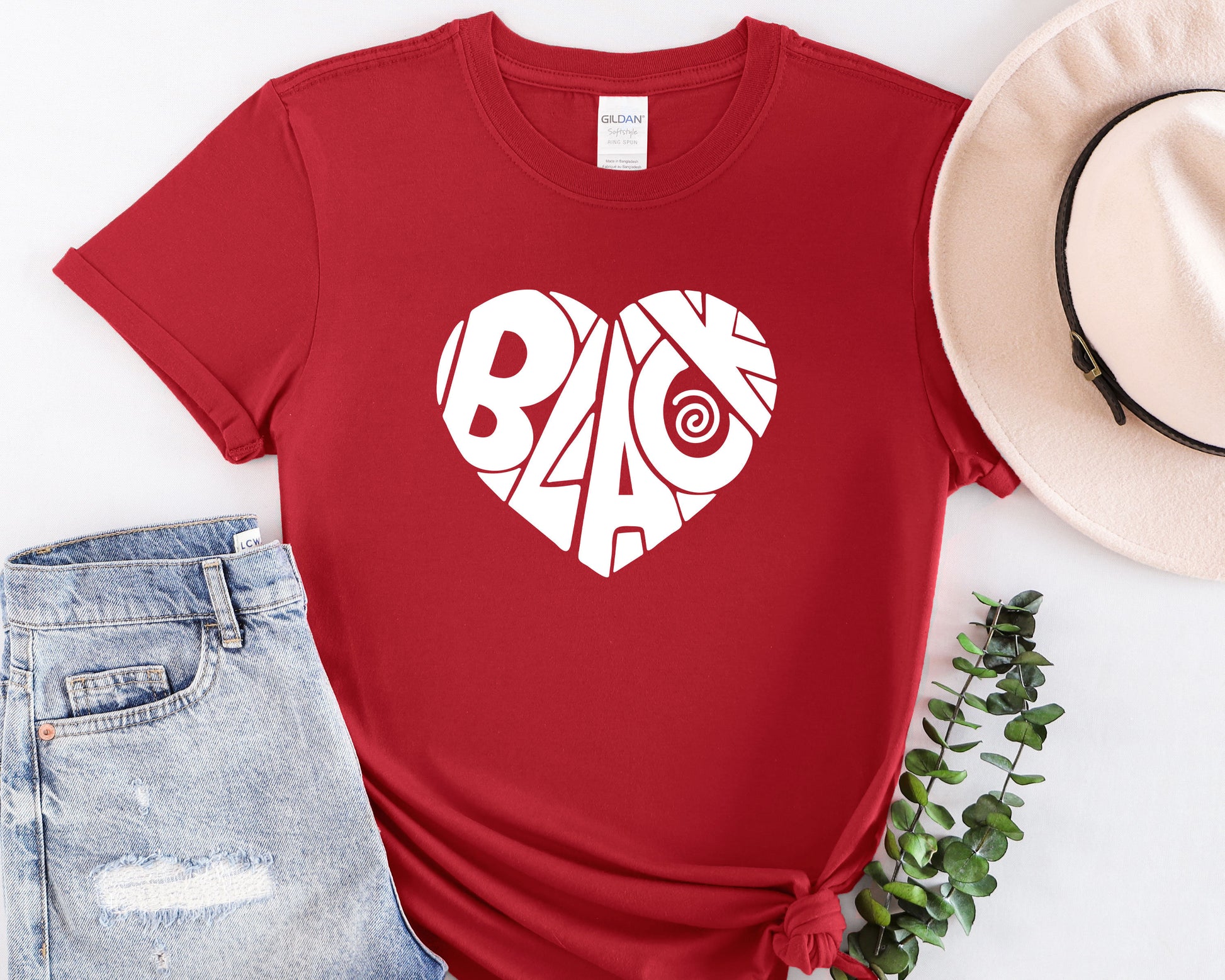 a red t - shirt with the word baq on it next to a hat