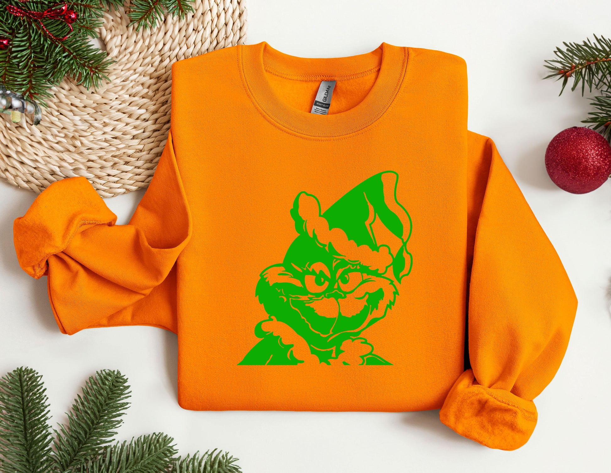 an orange sweatshirt with a green cat on it