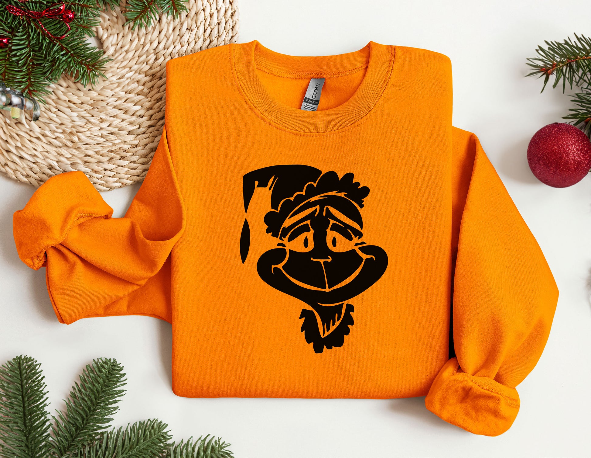 an orange sweater with a cartoon of a monkey wearing a santa hat