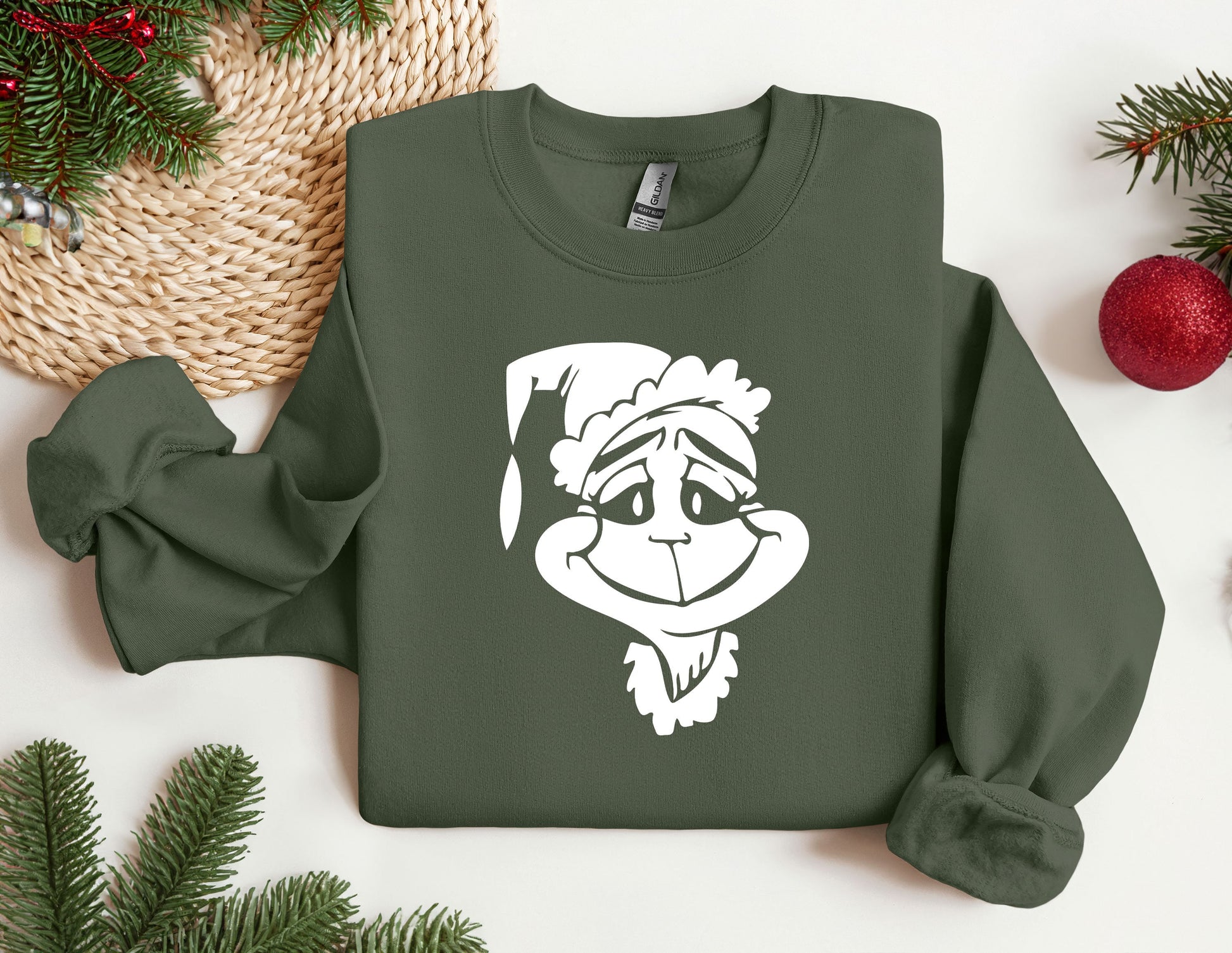 a green sweatshirt with a white image of a monkey wearing a santa hat