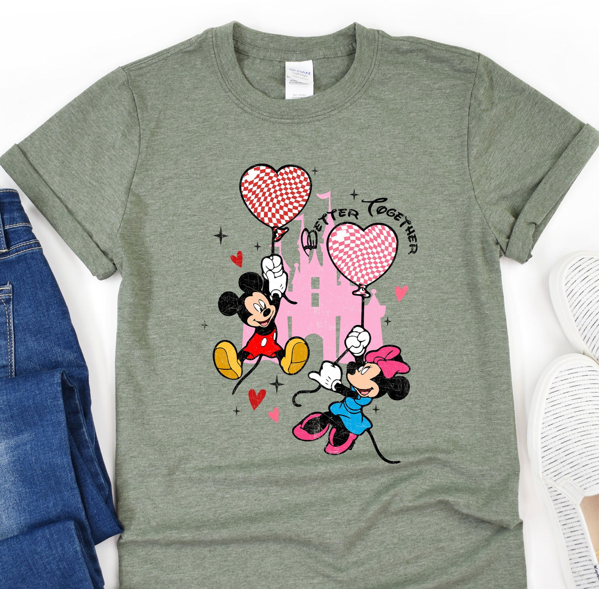 a mickey mouse and minnie mouse t - shirt next to a pair of jeans