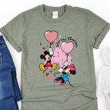 a mickey mouse and minnie mouse t - shirt next to a pair of jeans