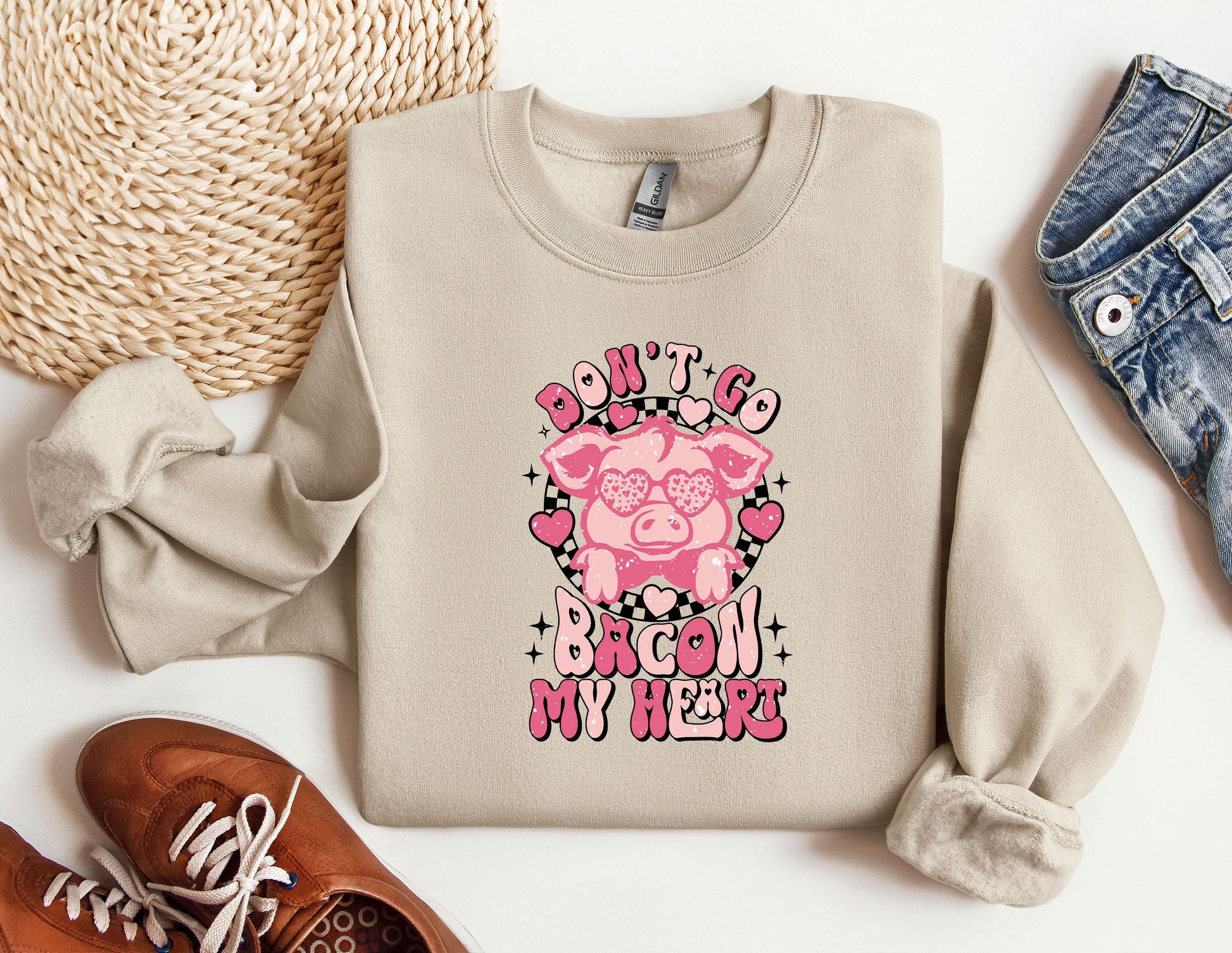 a sweater with a pig on it next to a pair of shoes