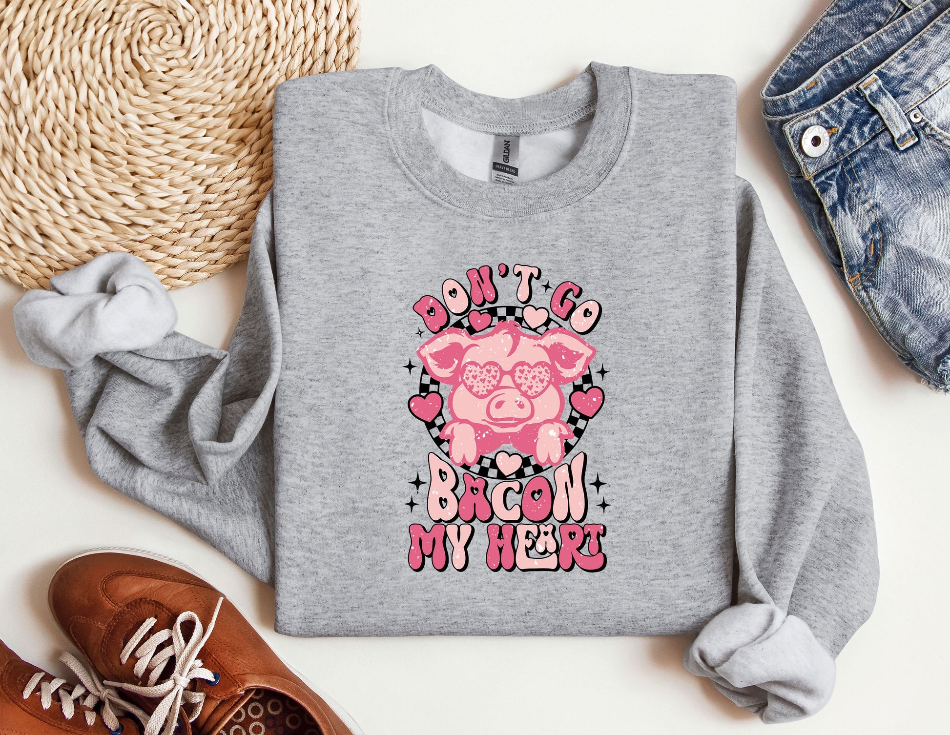 a gray sweatshirt with a pink pig on it