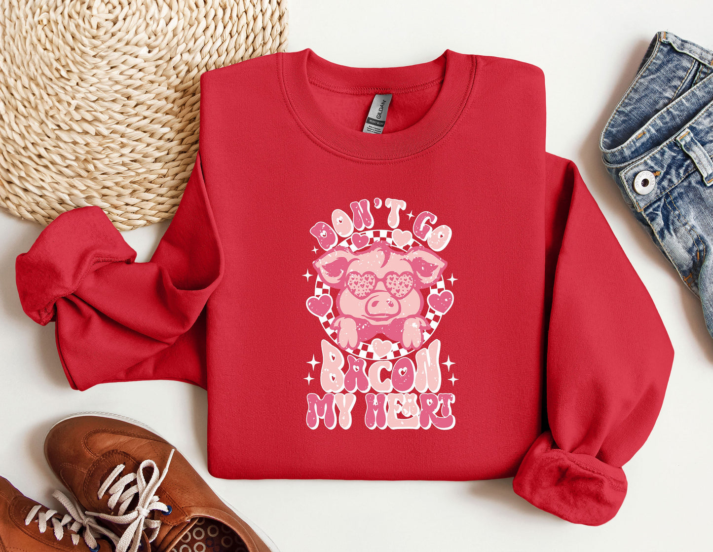 a red shirt with a pig on it next to a pair of shoes