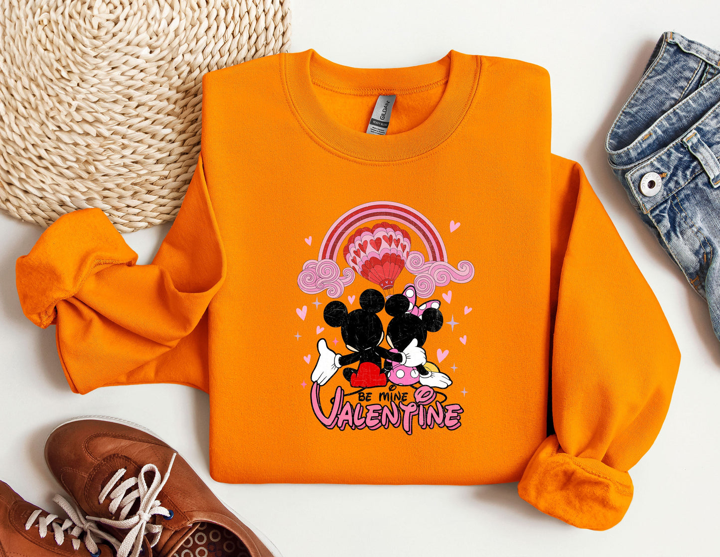 a pair of shoes and an orange shirt with a mickey mouse on it