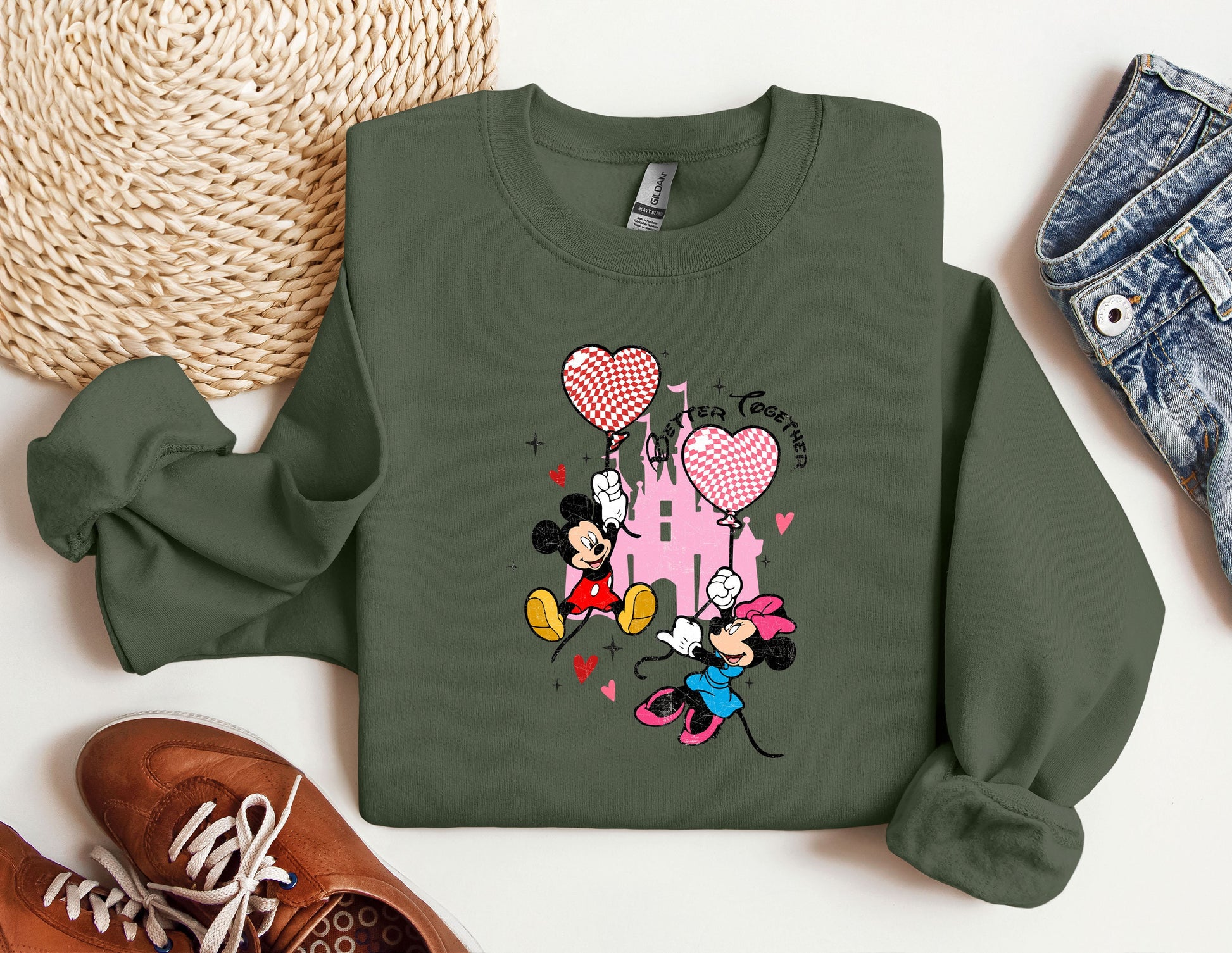 a green sweatshirt with mickey mouse and minnie mouse on it