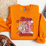 a pair of shoes and an orange sweatshirt with the word love is in the center
