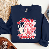 a blue sweatshirt with a picture of a house and hearts on it