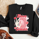 a black sweatshirt with a picture of a hand and hearts on it