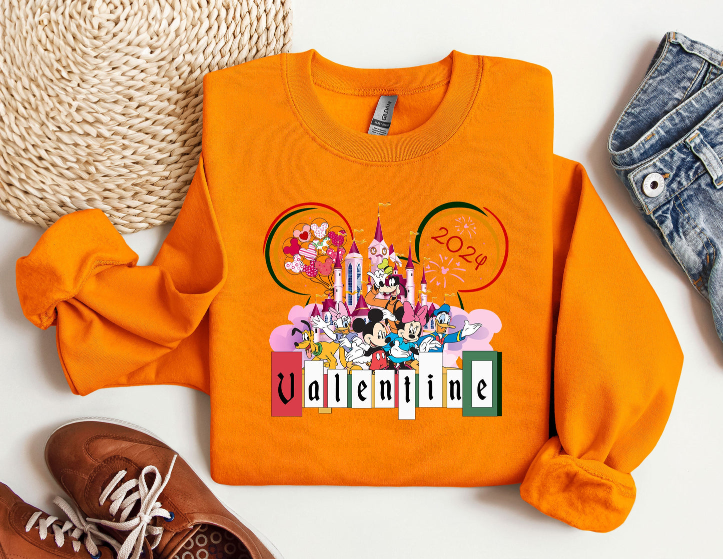 an orange shirt with mickey mouse on it next to a pair of shoes
