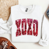 a white sweatshirt with the word dxo on it next to a pair of