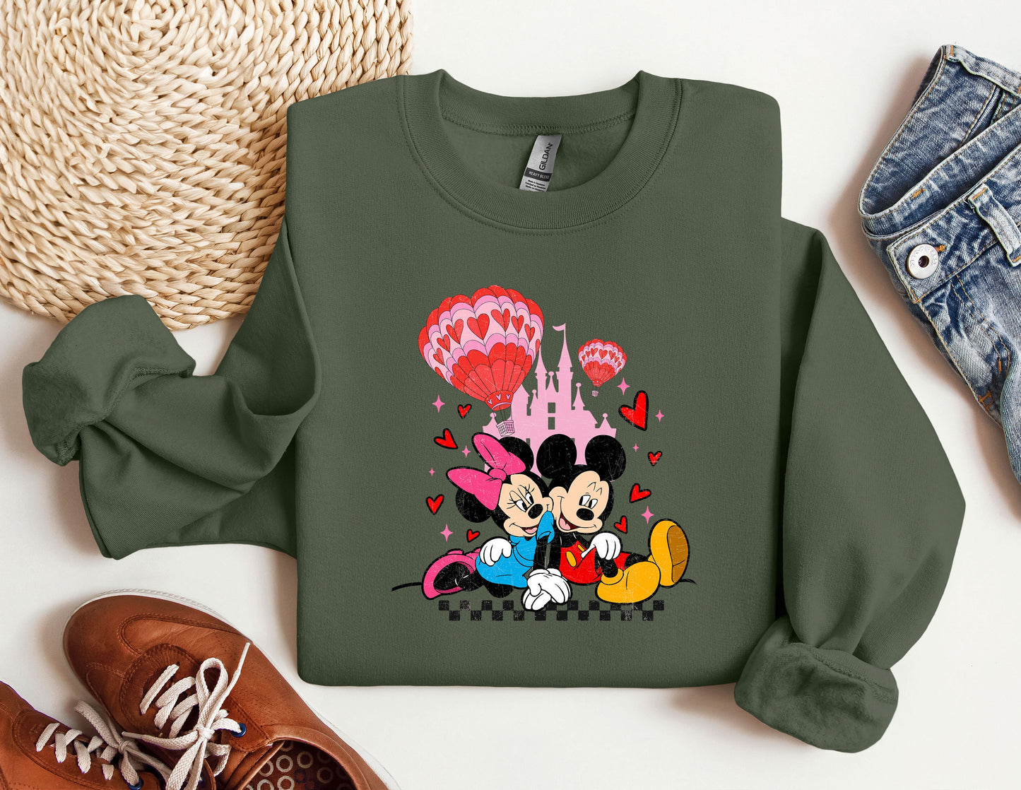 a green sweatshirt with a mickey mouse and minnie mouse on it