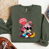 a green sweatshirt with a mickey mouse and minnie mouse on it