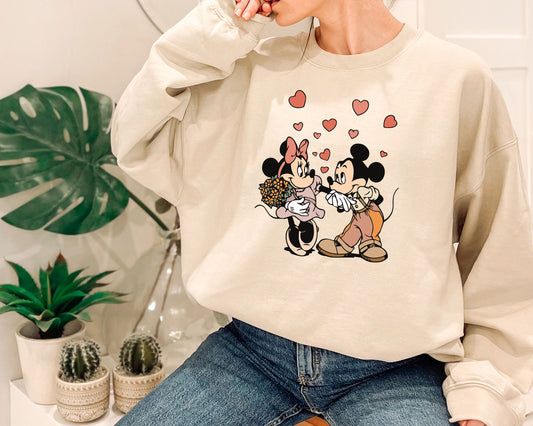 a woman wearing a mickey and minnie mouse sweatshirt