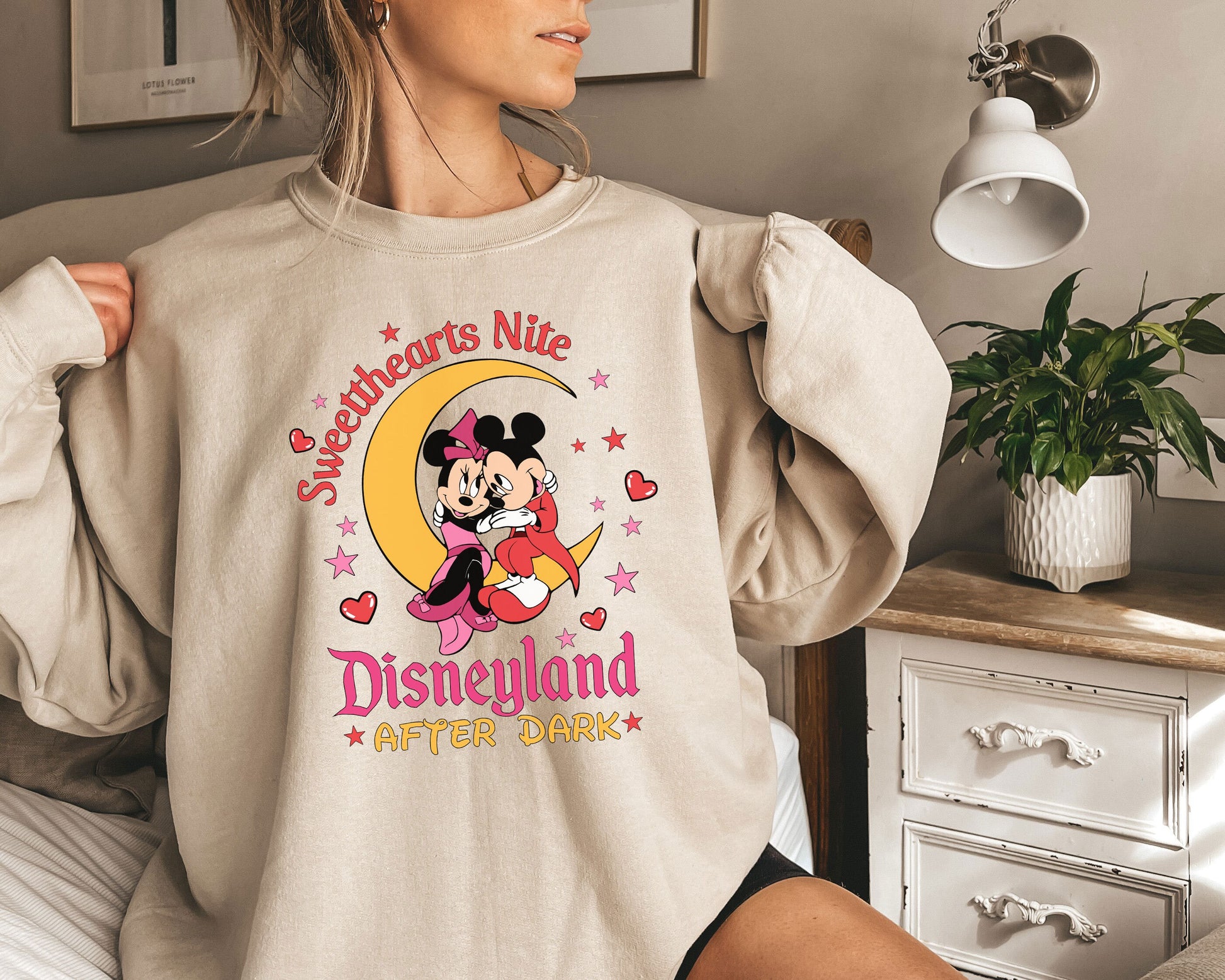 a woman wearing a sweatshirt with a mickey mouse on it