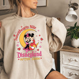 a woman wearing a sweatshirt with a mickey mouse on it