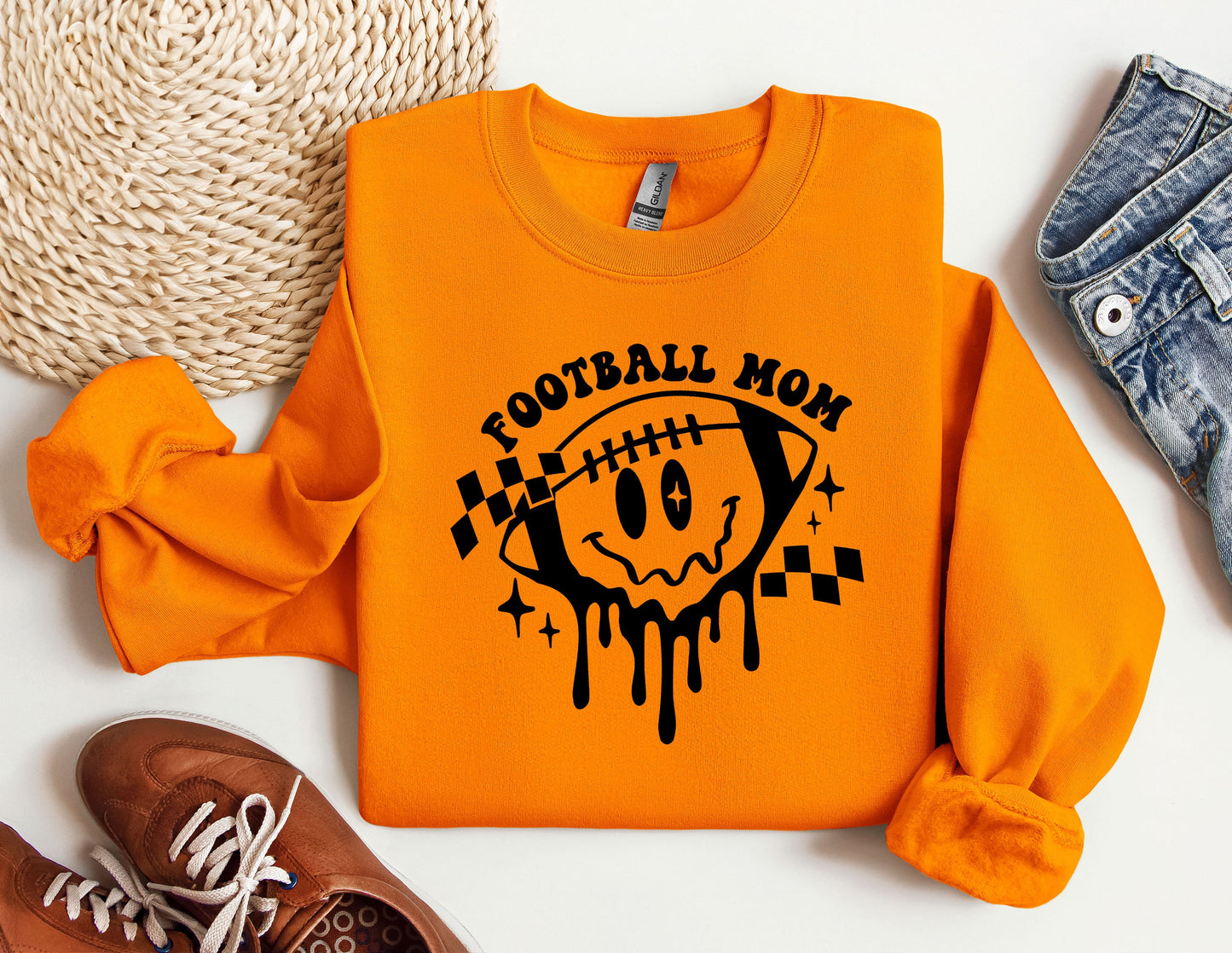 an orange football mom sweatshirt next to a pair of sneakers