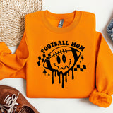 an orange football mom sweatshirt next to a pair of sneakers