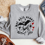 a grey sweatshirt with a bat on it next to a pair of jeans