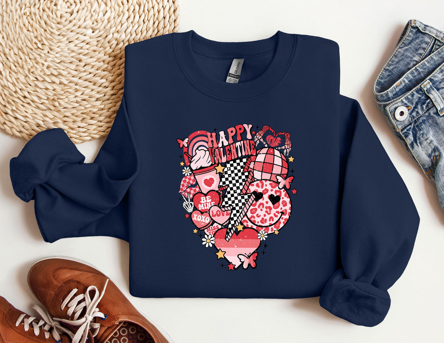 a blue sweatshirt with a heart on it next to a pair of shoes