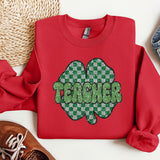 a red shirt with a shamrock on it next to a pair of shoes
