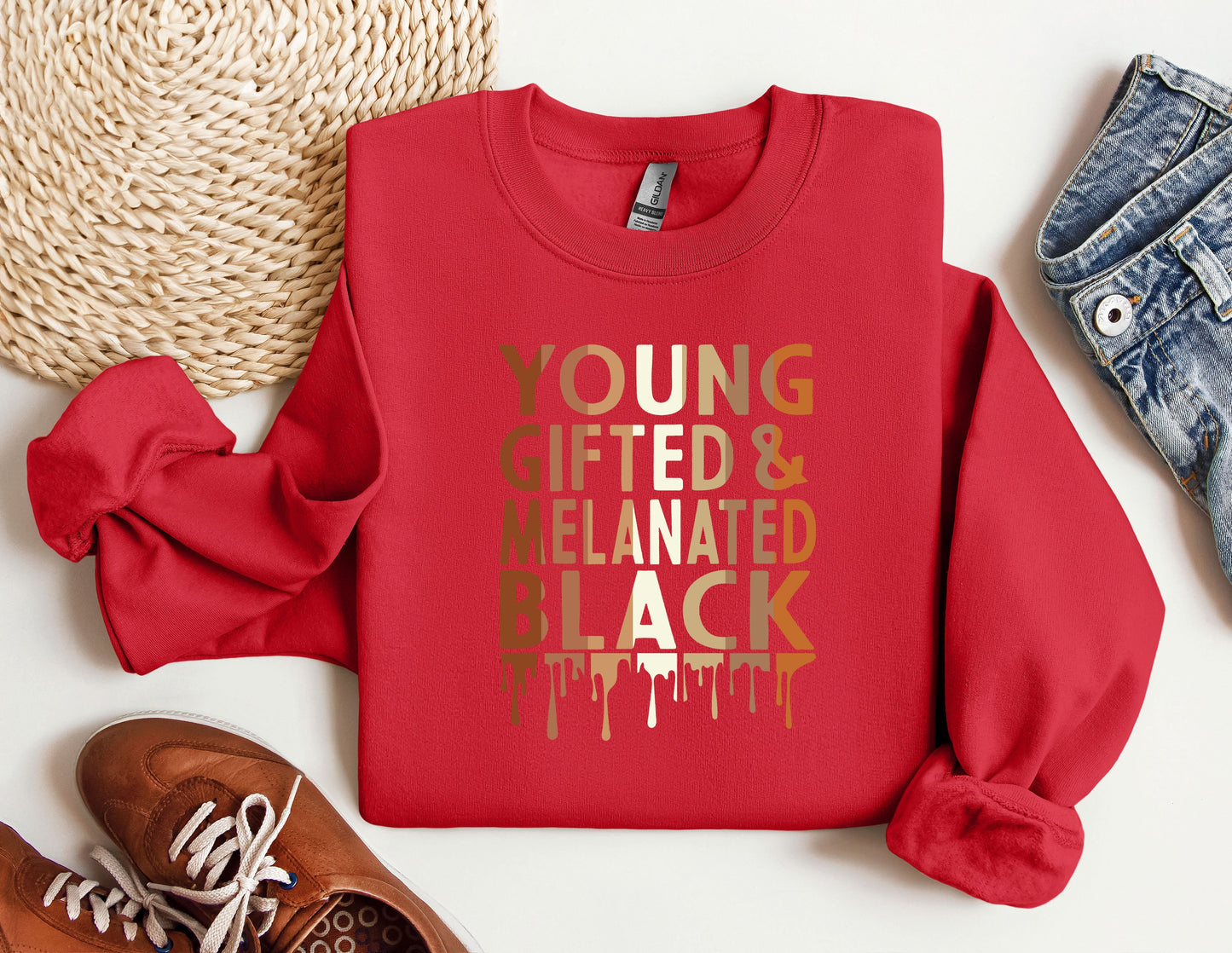 a red sweatshirt with the words young and related is next to a pair of sneakers