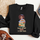 a black history month shirt with a black girl holding a stack of books